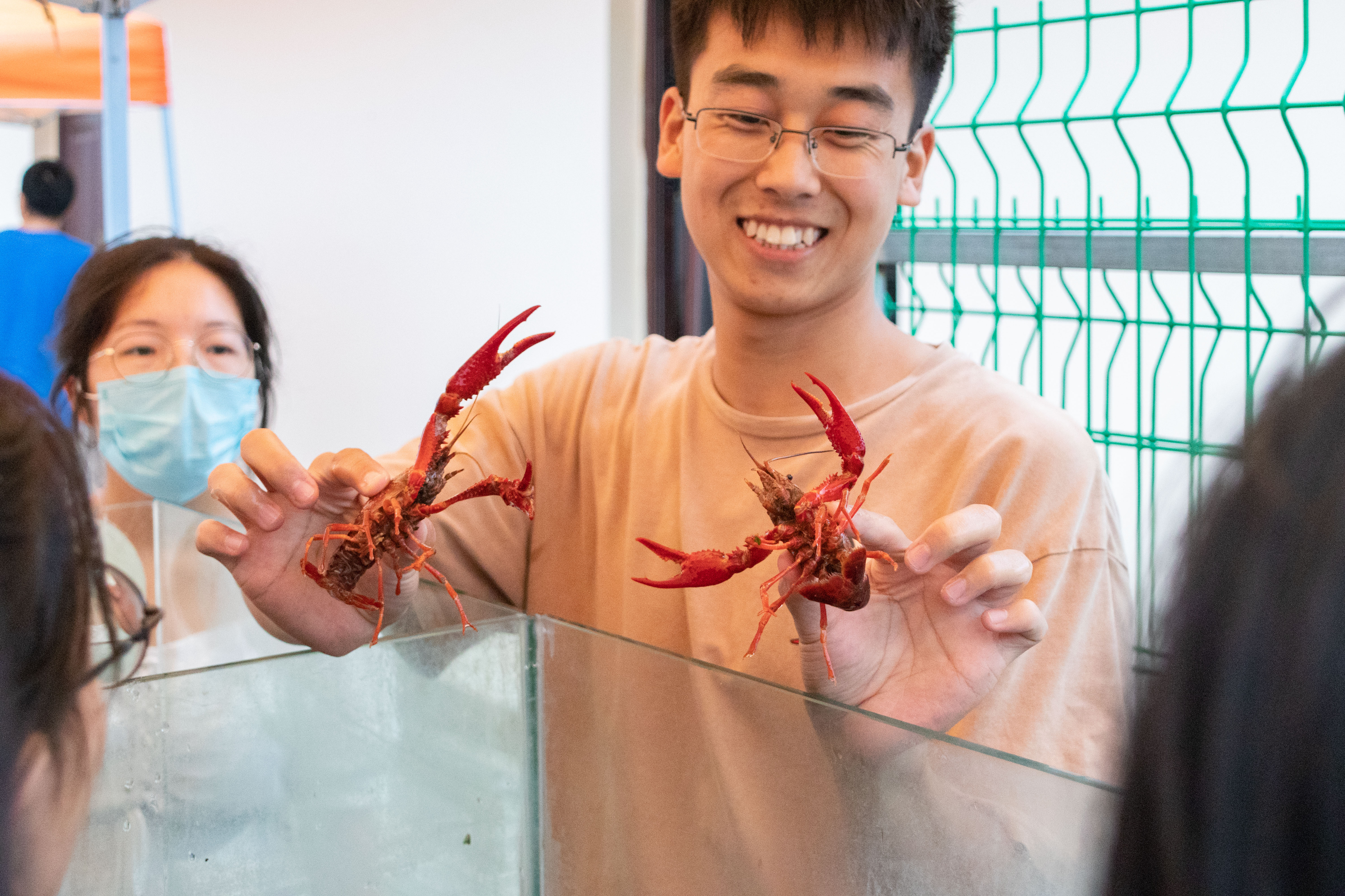 海燕策略官网19级研究生杨伟杰向新生讲解如何辨别小龙虾雌雄（学通社记者 周丹丹 摄）